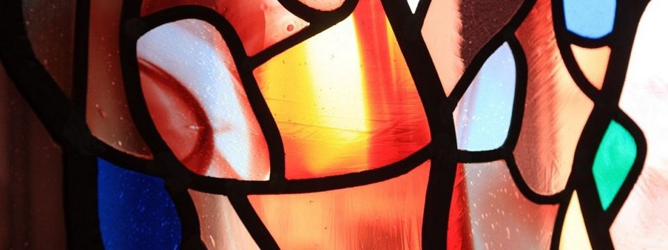 Buntes Fensterglas der Kapelle, durch das warmes Licht scheint